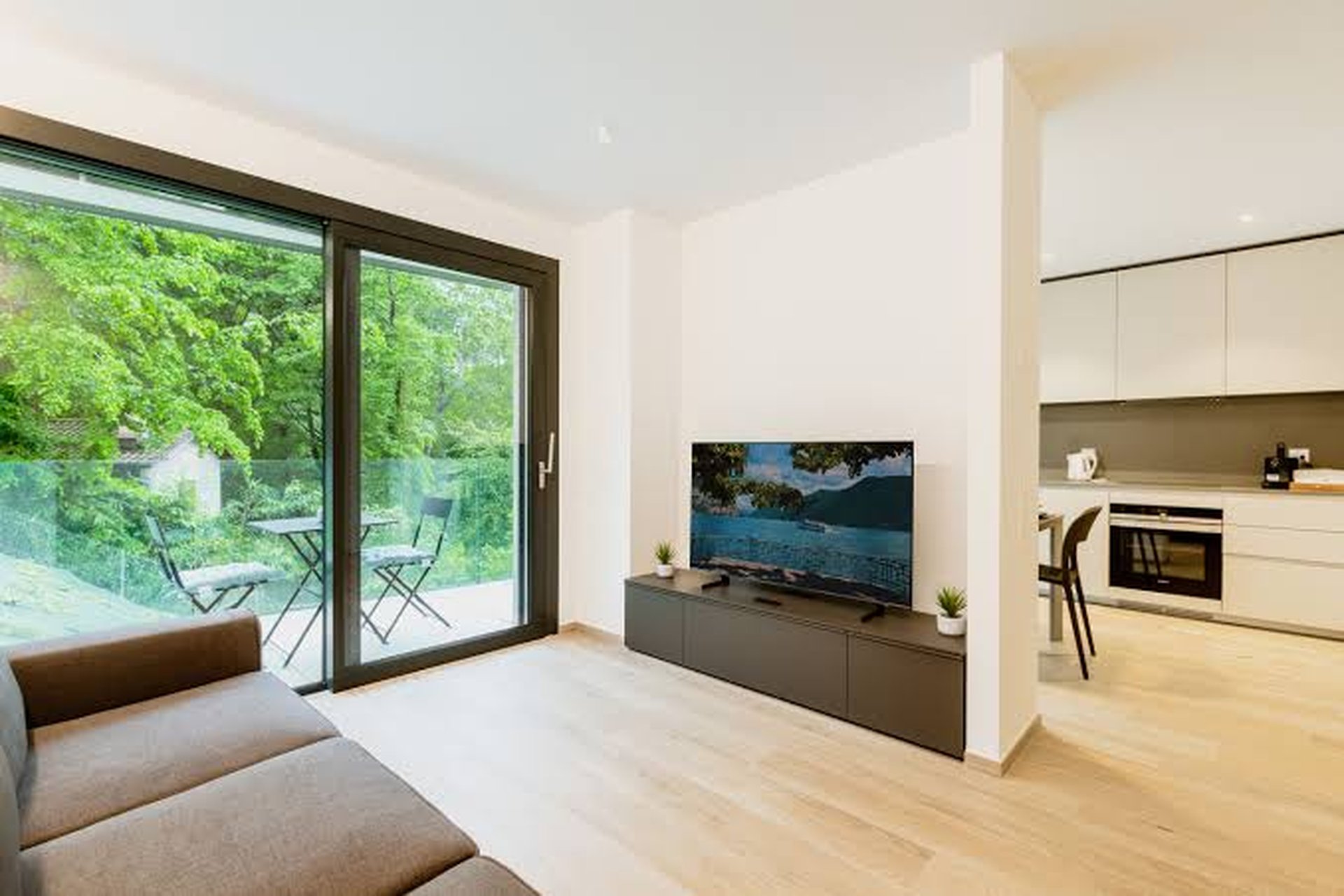 Salon lumineux d'un appartement avec grande baie vitrée sur un jardin